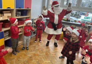 dzieci z grupy VII tańczą w kole z Mikołajem