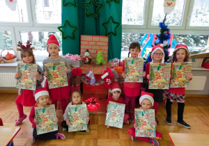 zdjęcie grupowe dzieci z grupy I przy kominku ze świątecznymi kalendarzami