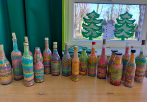 szklane butelki w różnych kształtach wypełnione kolorowym ryżem