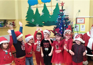 dzieci śpiewają i tańczą dla Mikołaja i ilustrują piosenkę ruchem