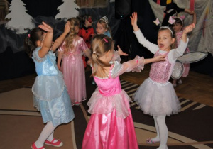 zabawa taneczna ze śpiewem: dziewczynki unoszą ręce do góry
