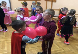 taniec dzieci w parach z różowymi balonami między nimi