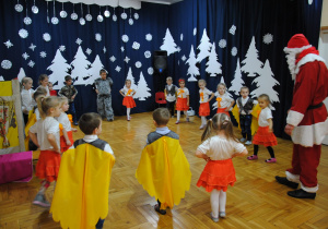 dzieci tańczą z Mikołajem w kole