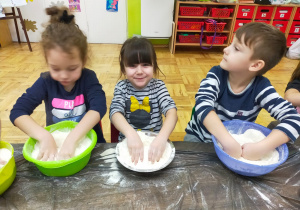dzieci mieszają rękami mąkę i sól w miskach
