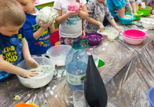 dzieci ugniatają kolorowe ciasto z masy solnej