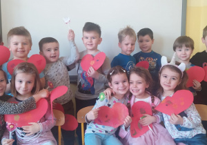 dzieci z grupy VIII z wielkimi czerwonymi sercami i lizakami