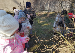 dzieci oglądają krzak z pąkami liści bzu