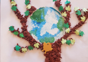 drzewo z kolorowymi liśćmi a między jej gałęziami planeta Ziemia - praca z wykorzystaniem kulek z bibuły
