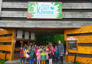 grupa dzieci z nauczycielką przed wejściem do Sadów Klemensa