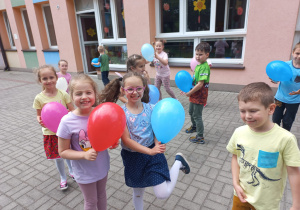 dzieci bawia się balonami na tarasie przedszkolnym