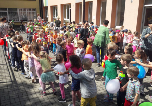 dzieci z nauczycielkami tańczą na terasie robiąc "węże"