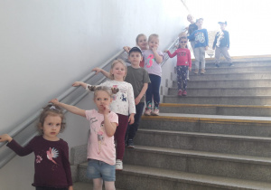 dzieci schodzą po schodach do przejścia pod peronami