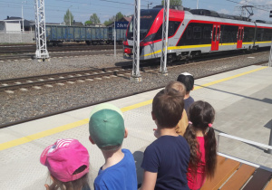 dzieci obserwują nadjeżdżający pociąg