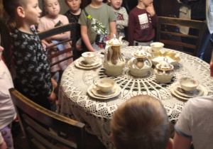 dzieci w domu rodzinnym Św. Maksymiliana - pokój z dużym okrągłym stołem, przykrytym białą serwetą i ustawionym serwisem kawowym