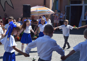 "Polonez" w wykonaniu dzieci z grupy V - dziewczynki ubrane w białe bluzki oraz niebieskie spódniczki i kokardy na kitkach (dziewczynki) a chłopcy w białych koszulach i długich spodniach
