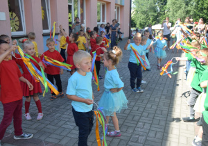 dzieci z grupy IV tańczą z obręczami ozdobionymi kolorowymi wstążkami