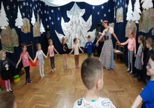 tancerka w stroju śląskim tańczy z dziećmi w kole i śpiewa