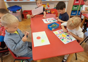 dzieci przy stoliku rysują kropki