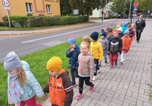 przedszkolaki poruszają się parami prawą stroną chodnika