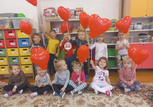 dzieci z grupy V z balonikami w kształcie czerwonych serduszek