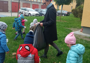 przedszkolaki zbierają śmieci na trawnikach osiedlowych