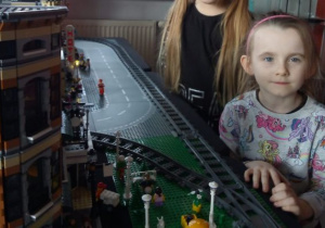 dzieci oglądają stację kolejową zbudowaną z klocków Lego