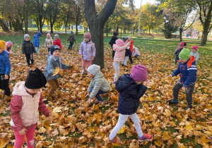 dzieci chodzą po kolorowych liściach