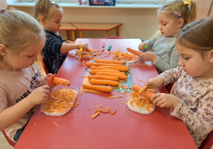 dzieci obierają marchewki obieraczkami do warzyw