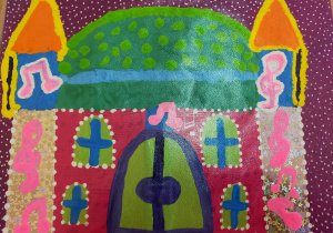 praca plastyczna wykonana z kolorowego papieru i malowana farbami - kolorowy zamek z zieloną kopułą w jasno zielone kropki, z dwiema, złotymi wieżami ozdobionymi różowymi nutkami, zieloną bramą i oknami z nebieskimi okiennicami