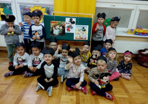 dzieci z grupy II pozują do zdjęcia grupowego w czarnych opaskach z uszami Myszki Miki