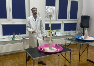 chemik demonstruje białą lawę wulkaniczną, która wystrzela wysoko w górę z butelki