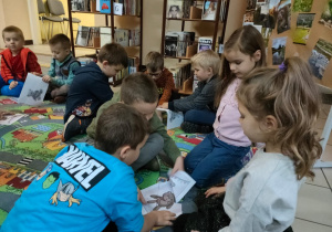 w bibliotece - dzieci układają puzzle z misiem