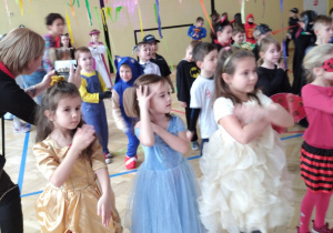 dziewczynki tańczą ustawione w szeregu i wykonują ruchy rękami