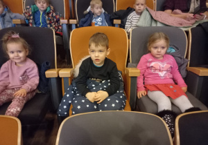 dzieci w siedzą na fotelach w kinie