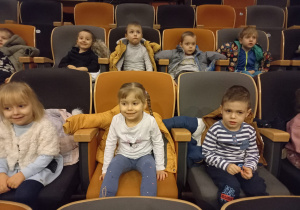 dzieci rozsiadły się w fotelach w kinie