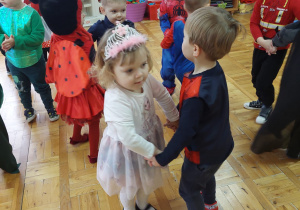 dzieci tańczą w parach w kostiumach karnawałowych