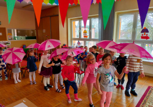 dzieci tańczą z parasolkami