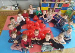 zdjęcie grupowe dzieci z grupy VII z czerwonymi balonami w kształcie serc