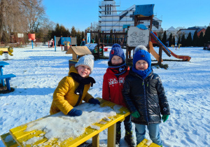 w ogrodzie zimowym - chłopcy stoją przy ośnieżonym stoliku