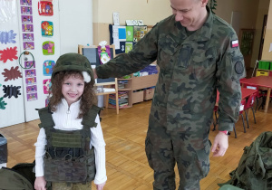 żołnierz i dziewczynka w kamizelce i hełmie wojskowym