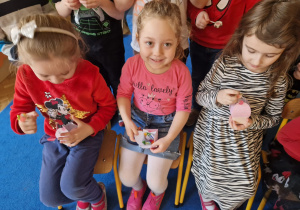 dziewczynki rozpakowują różowe pudełka wypełnione cukierkami
