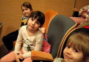 dzieci siedzą w fotelach w sali widowiskowej ratusza