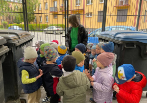 przedszkolaki w pergoli śmietnika przyglądają się rodzajom i kolorom pojemników na śmieci