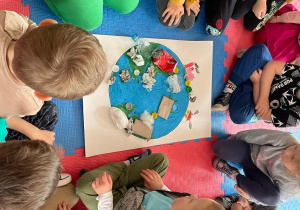 przedszkolaki w sali wykonują pracę plastyczną o zaśmieconej planecie