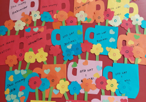 kubeczki kolorowe z kwiatkami z napisem "sto lat i buziaki"