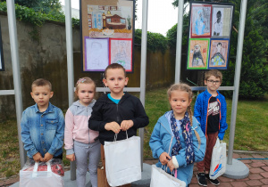 przedszkolaki z nagrodami stoją przed swoimi pracami w Muzeum Historii Miasta w Zduńskiej Woli