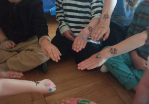 dzieci prezentują swoje tatuaże na rękach