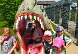 dzieci pozują do zdjęcia w paszczy dinozaura