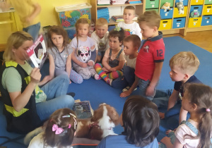dzieci oglądają książeczkę o psie