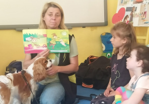 instruktorka czyta i pokazuje ilustracje w książce o psie
